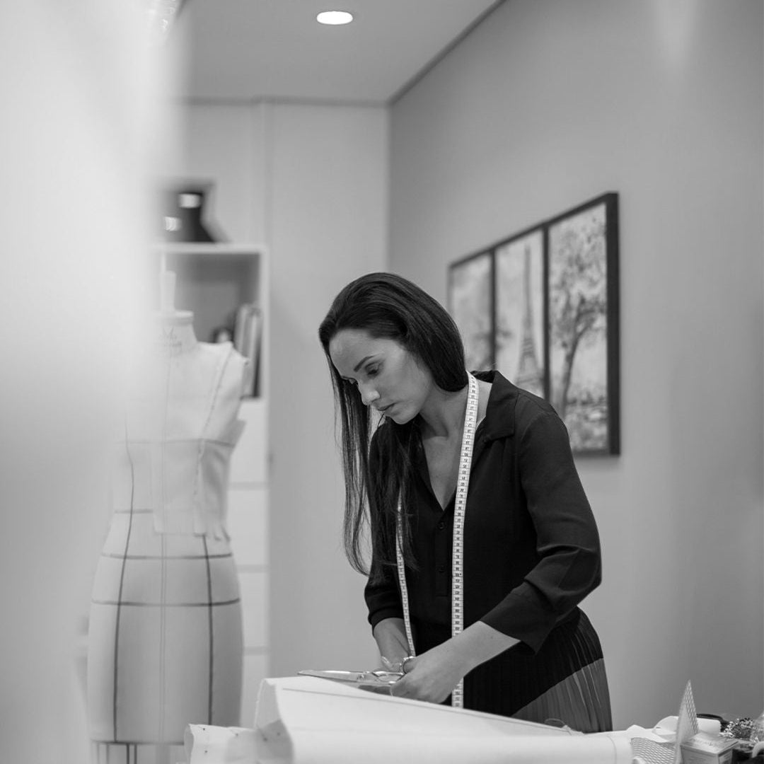 Woman standing in a modern kitchen looking at a tablet device.
